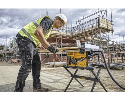Ein Bauarbeiter bedient eine Tischkreissäge auf einer Baustelle.