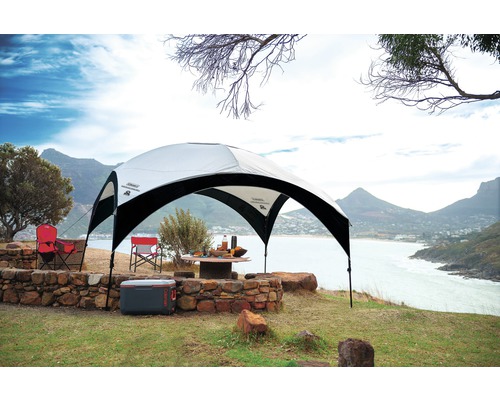 Szene mit Pavillon, Kühlbox und Campingstühlen im Freien mit Blick auf das Meer