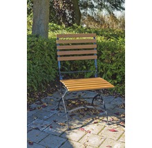 Gartenszene mit einem einzelnen Holzklappstuhl auf einer Terrasse
