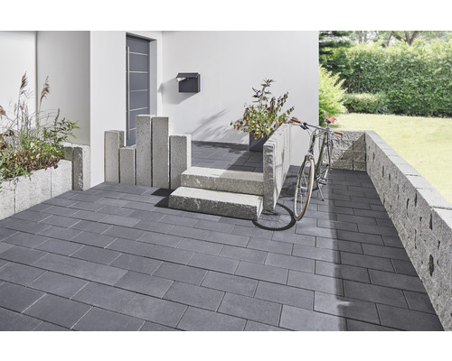 Eingangsbereich mit Pflastersteinen, Mauer und Treppe aus Stein