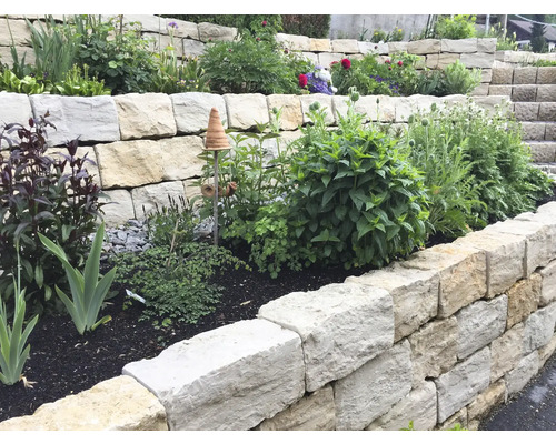 Gestufter Garten mit Natursteinmauer und Pflanzen