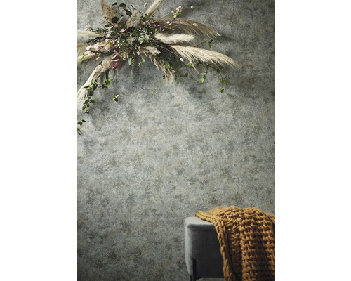 Wand mit Blumenschmuck und Hocker mit Strickdecke