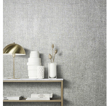 Nahaufnahme einer Wand mit Textiltapete und einem Tisch mit Dekoration