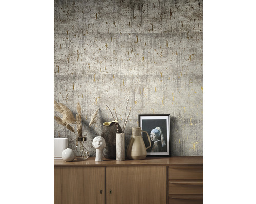 Nahaufnahme einer Wand mit grauer Beton Tapete und goldenen Akzenten