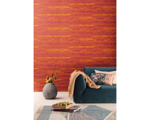 Wohnzimmer mit orangefarbener Vinyltapete, Sofa, Kissen und Blumenvase
