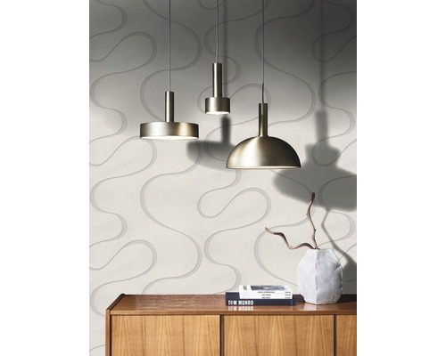 Drei Pendelleuchten aus Metall hängen vor einer Wand mit gewelltem Muster.
