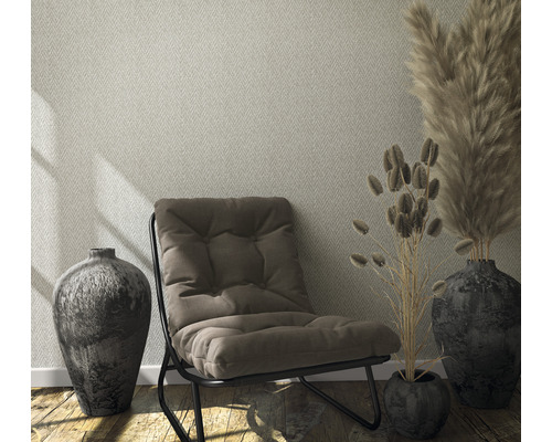 Wohnraum mit gemusterter Tapete, Sessel und Dekoration in Vasen.