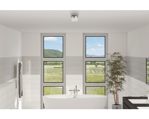 Modernes Badezimmer mit freistehender Badewanne, Heizkörper, Fenstern mit Ausblick und Deckenleuchte