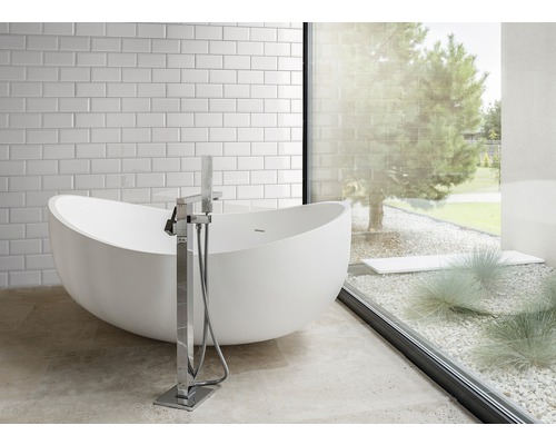 Modernes Badezimmer mit freistehender Badewanne und großem Fenster zum Garten