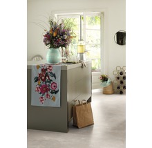 Dekoratives Arrangement in einer hellen Küche mit Blumen, Getränkespender und Stoffläufer