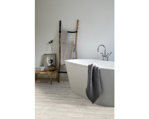 Badezimmer mit Badewanne, Handtuchleiter und Sitzbank