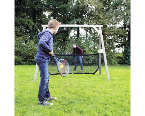 Zwei Personen spielen Tennis mit einem Tennisnetz im Garten.