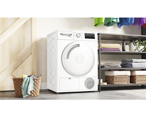 Freistehender Wäschetrockner von Bosch im Waschraum mit Wäschekorb und Regal