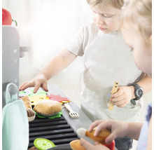 Kinder spielen mit einer Spielküche und Lebensmitteln aus Stoff.