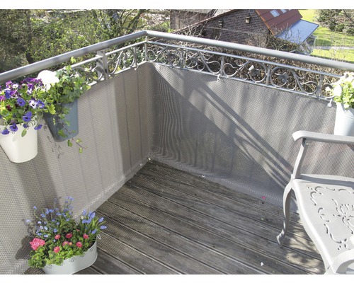 Balkon mit Sichtschutz, Stuhl und Blumenkästen.