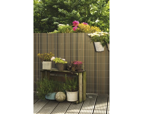 Gartenszene mit Sichtschutzzaun, Pflanztisch und Blumen in Töpfen