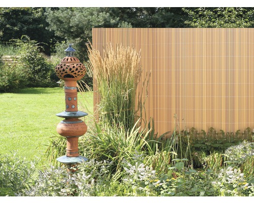 Garten mit Sichtschutzzaun und dekorativer Gartenskulptur