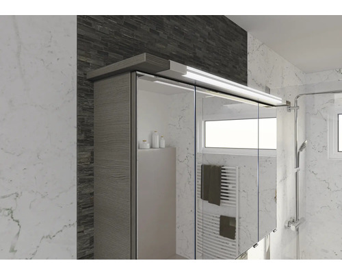 Badezimmerszene mit Spiegelschrank, Handtüchern, Heizkörper und Dusche.