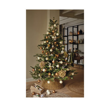 Dekorierter Weihnachtsbaum mit Christbaumkugeln und Lichtern im Wohnzimmer.