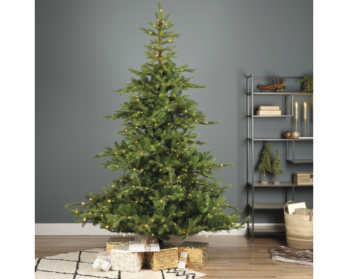 Geschmückter Weihnachtsbaum mit Geschenken im Wohnzimmer.