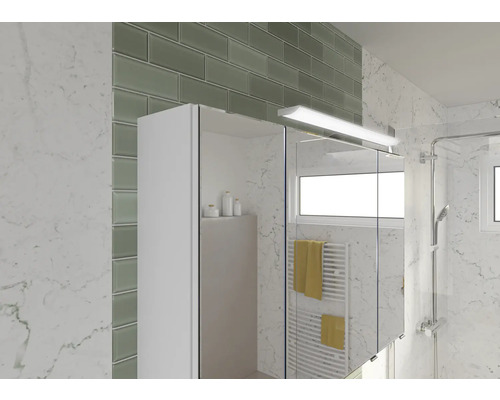 Badezimmer mit Spiegelschrank, Fliesen und Dusche.