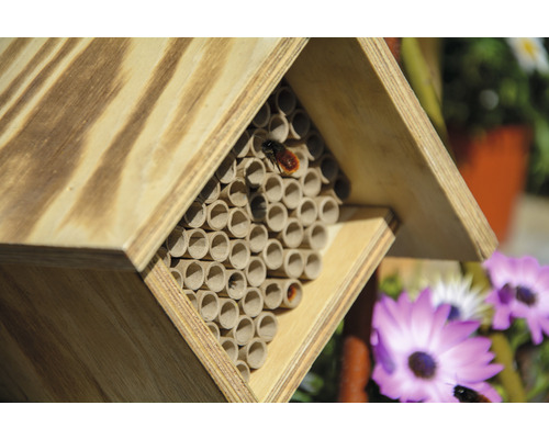 Insektenhotel aus Holz mit Röhren als Nistplätze für Insekten.