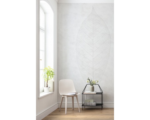 Heller Raum mit Stuhl, Beistelltisch, Pflanze und Wandtattoo in Blattoptik