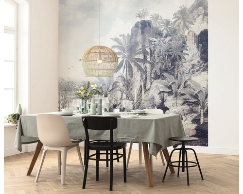 Esszimmer mit Esstisch, Stühlen, Hängelampe aus Rattan und tropischer Fototapete.