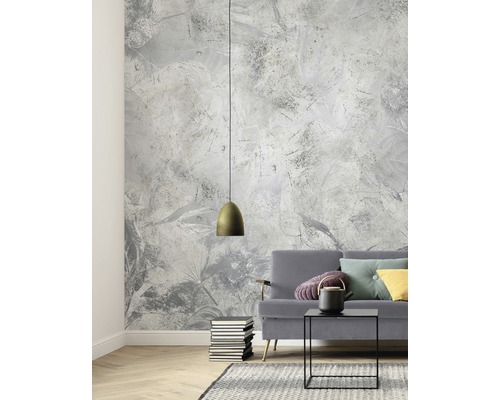 Wohnzimmer mit gemusterter Tapete, Pendelleuchte, Sofa, Tisch und Teppich