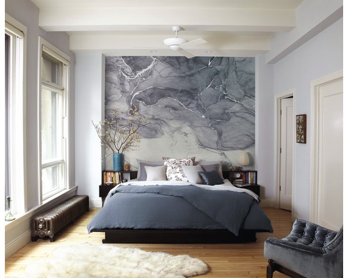 Schlafzimmer mit Bett, Nachttischen, Dekor und gemusterter Tapete