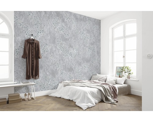 Helles Schlafzimmer mit gemusterter Tapete, Bett und Holzboden