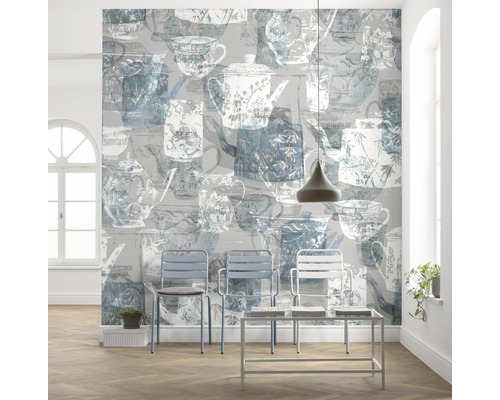 Helles Zimmer mit Tapete, die Teekannen und Tassen darstellt, sowie Stühlen und einem Tisch