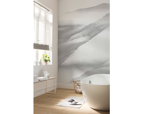 Badezimmer mit Badewanne und Fototapete mit Bergmotiv