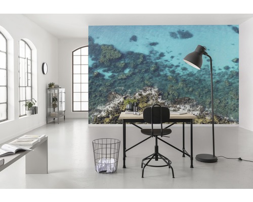 Heller Raum mit Schreibtisch, Stuhl, Stehlampe und Fototapete mit Meeresmotiv