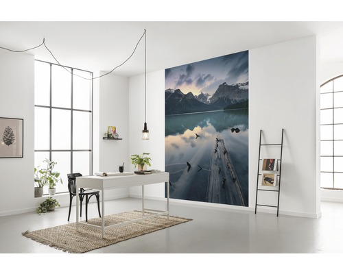 Modernes Arbeitszimmer mit Schreibtisch, Stuhl, Leiterregal und Fototapete mit Bergseelandschaft