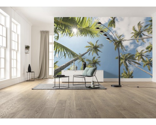 Wohnzimmer mit Fototapete mit Palmenmotiv, Stehlampe, Sessel und Tisch