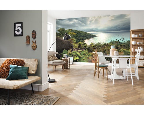 Wohnzimmer mit Fototapete einer tropischen Insel, einem Sofa, einem Tisch und Stühlen.