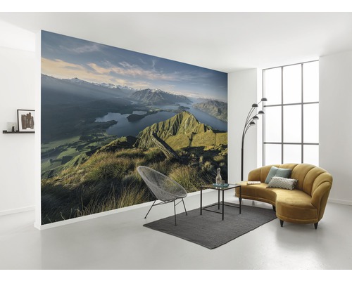 Wohnraum mit Fototapete Berglandschaft, Sofa, Sessel und Teppich