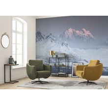 Wohnzimmer mit Fototapete mit Bergmotiv, zwei Drehsesseln und einem Beistelltisch