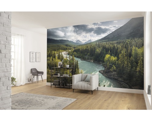 Wohnraum mit Fototapete einer Flusslandschaft mit Bergen und Bäumen
