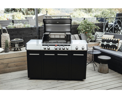 Gasgrill mit geöffnetem Deckel auf einer Terrasse