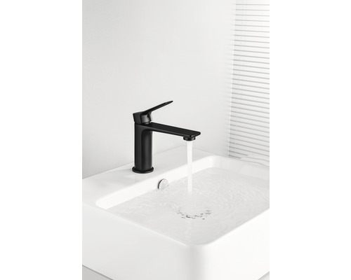 Schwarzer Waschtisch Wasserhahn mit laufendem Wasser in einem Waschbecken.