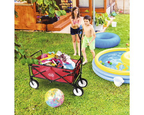 Szene im Garten mit Bollerwagen, Planschbecken und zwei Kindern