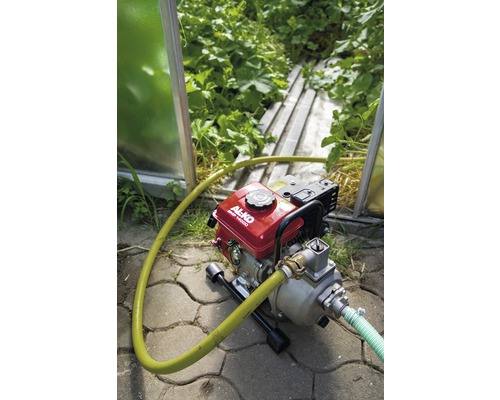 Motorpumpe mit Schlauch im Garten zur Bewässerung