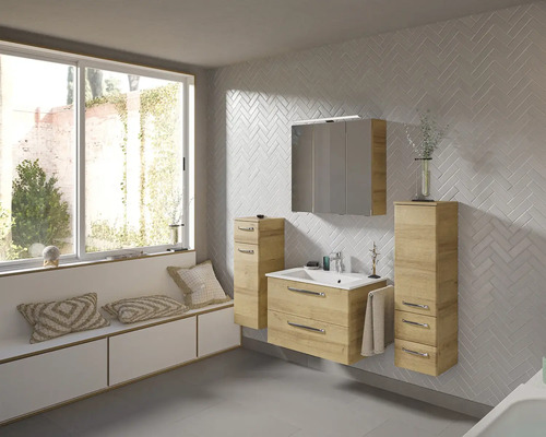Badezimmer mit Waschtisch, Spiegelschrank und Unterschränken in hellem Holzdekor vor einer Wand mit Fischgrätmuster