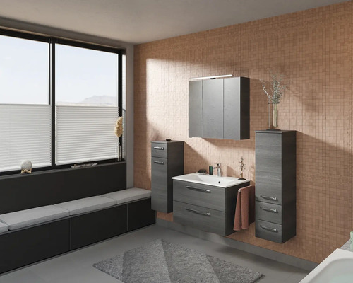 Badezimmer mit Waschtisch, Spiegelschrank und Unterschrank in Holzoptik sowie Fensterbank mit Sitzgelegenheit