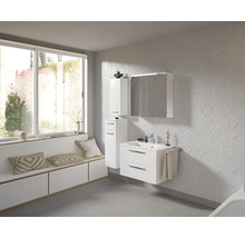 Helles Badezimmer mit Waschtisch, Spiegelschrank und Hochschrank in weißem Design vor einer Wand mit Fischgrätenmuster.
