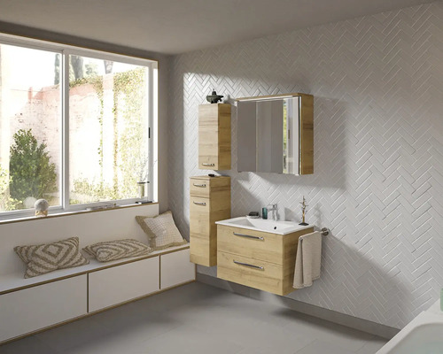 Helles Badezimmer mit Waschtisch, Spiegelschrank und Hochschrank in Holzausführung, ergänzt durch eine Fensterbank mit Kissen