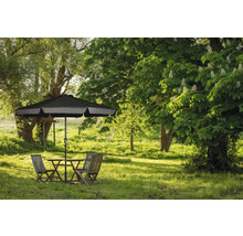 Gartenszene mit Tisch, Stühlen und Sonnenschirm auf einer grünen Wiese