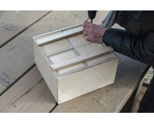 Holzkiste mit Schrauben, zusammengebaut mit einem Schraubenzieher